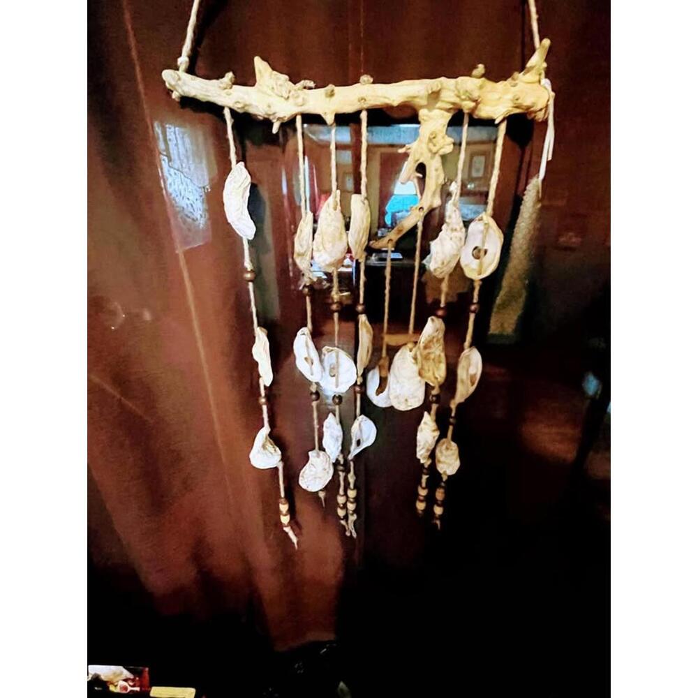 A handcrafted, driftwood and shell mobile/wind chime with beaded enhancements.